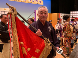 栄光の成田雲竹旗を手にする岩谷勇さん